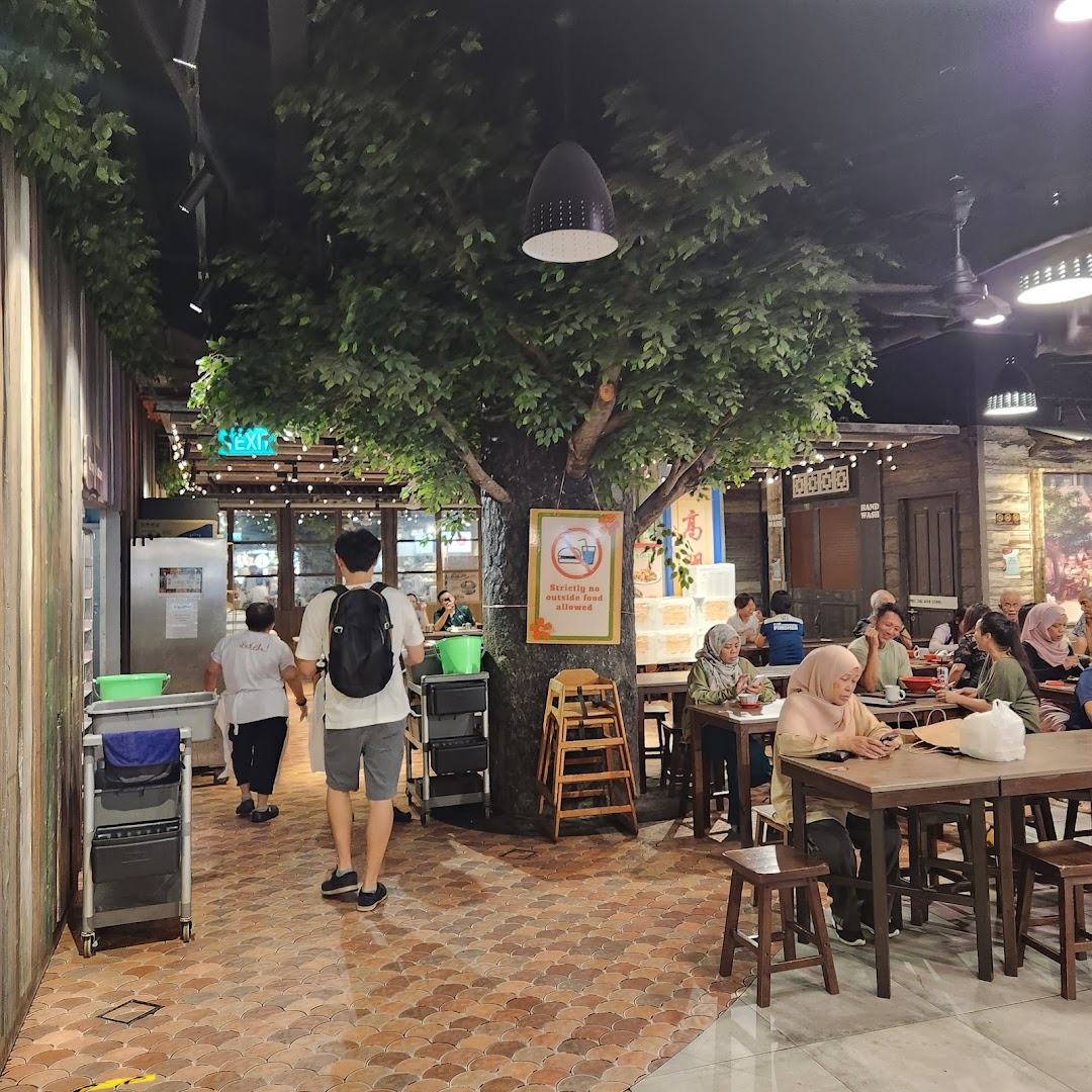 Diners enjoy a meal in the cozy, tree-themed interior of Boleh Boleh! food court at Clementi Mall.