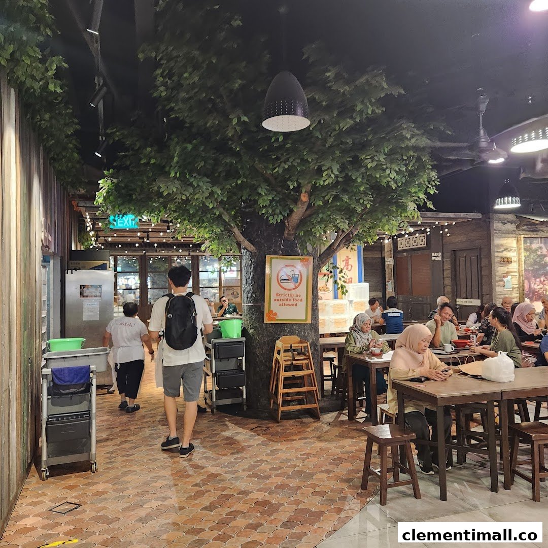 Diners enjoy a meal in the cozy, tree-themed interior of Boleh Boleh! food court at Clementi Mall.