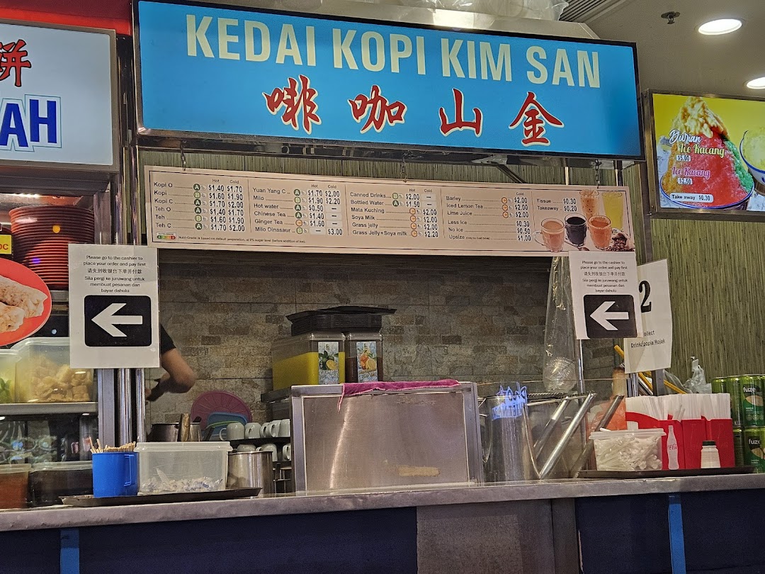 A food stall counter with a prominent menu board displaying traditional drinks and desserts.