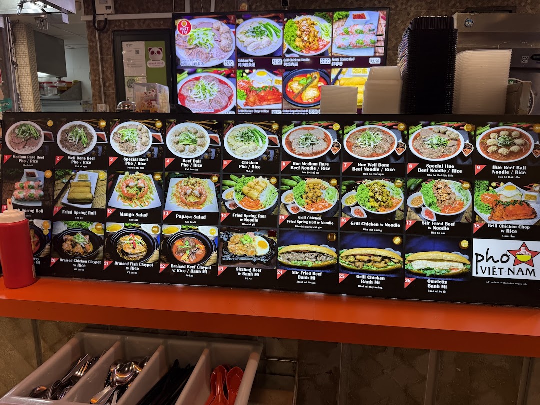 A vibrant menu board displaying a variety of Vietnamese dishes, including pho, noodles, rice, and banh mi.
