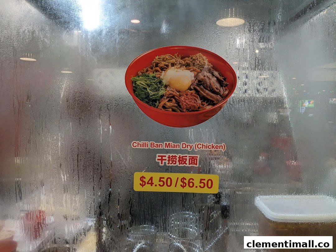 A close-up of a steamed-up glass display featuring a delicious bowl of Chilli Ban Mian Dry (Chicken) with its price.