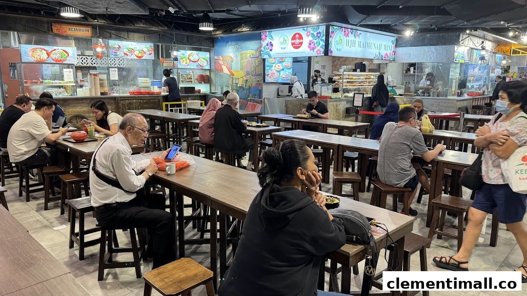 Diners enjoy meals at various food stalls within a bustling food court.