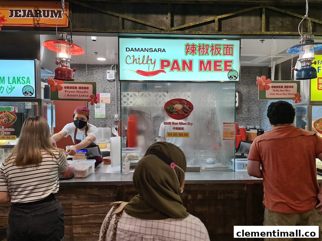 Customers ordering from Damansara Chilly Pan Mee and Jejrum Laksa stalls at a bustling food court.