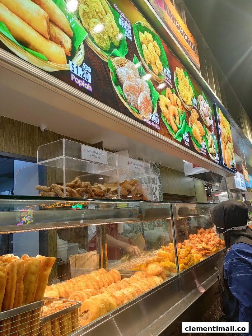 A vibrant display of fried local snacks at Boleh Boleh! with a clear menu board showing prices.