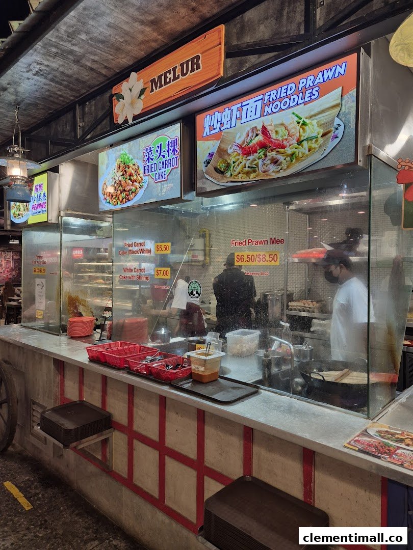 A bustling food stall counter at Boleh Boleh! Clementi Mall, showcasing popular local dishes and active food preparation.