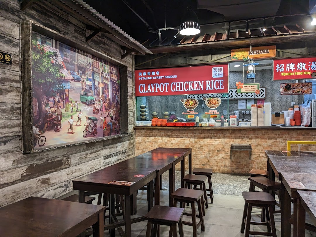 Interior view of a Claypot Chicken Rice stall featuring traditional decor, wooden tables, and a vibrant street mural.