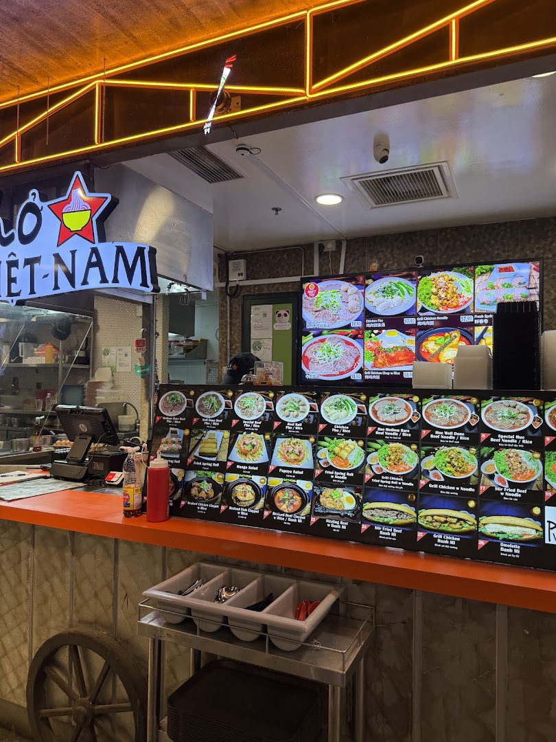 A vibrant food stall counter at Boleh Boleh! Clementi Mall, showcasing a variety of Vietnamese dishes.