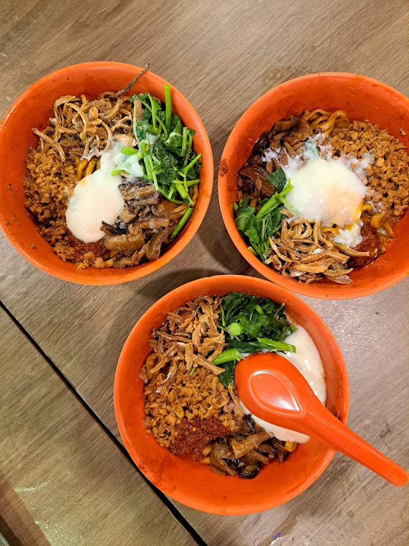 Three vibrant bowls of delicious noodles topped with minced meat, vegetables, anchovies, and a poached egg.