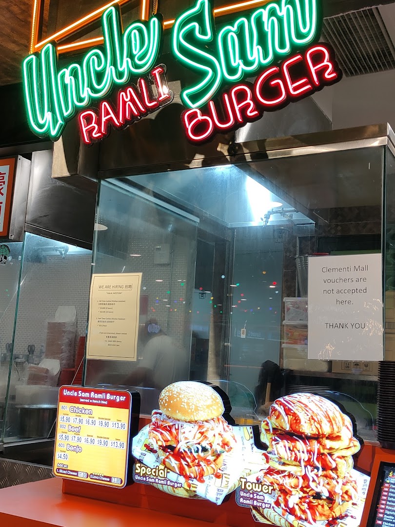 Front counter of Uncle Sam Ramli Burger with neon sign, menu board, and burger displays.