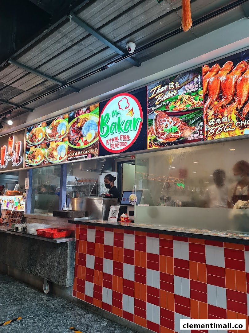 A vibrant food stall counter featuring large display boards showcasing grilled ayam, fish, and seafood dishes.