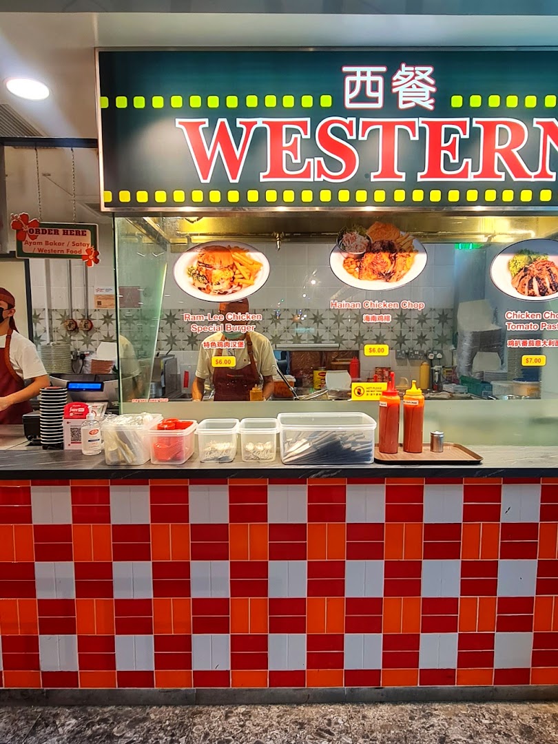 A food stall counter named 'Western' displaying various chicken and burger dishes with prices.