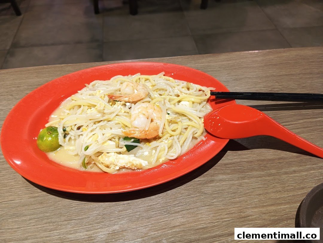 A vibrant plate of Hokkien Mee with fresh prawns and a calamansi lime.