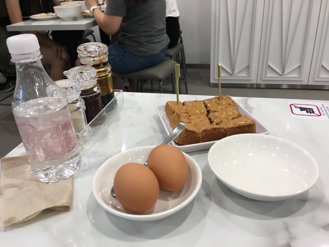 A table set with toast, eggs, water, and condiments, showing a casual dining experience.