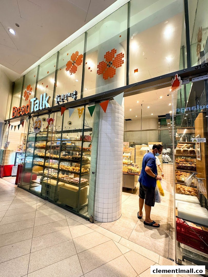 The inviting storefront of BreadTalk bakery, showcasing a variety of freshly baked goods and a customer entering.