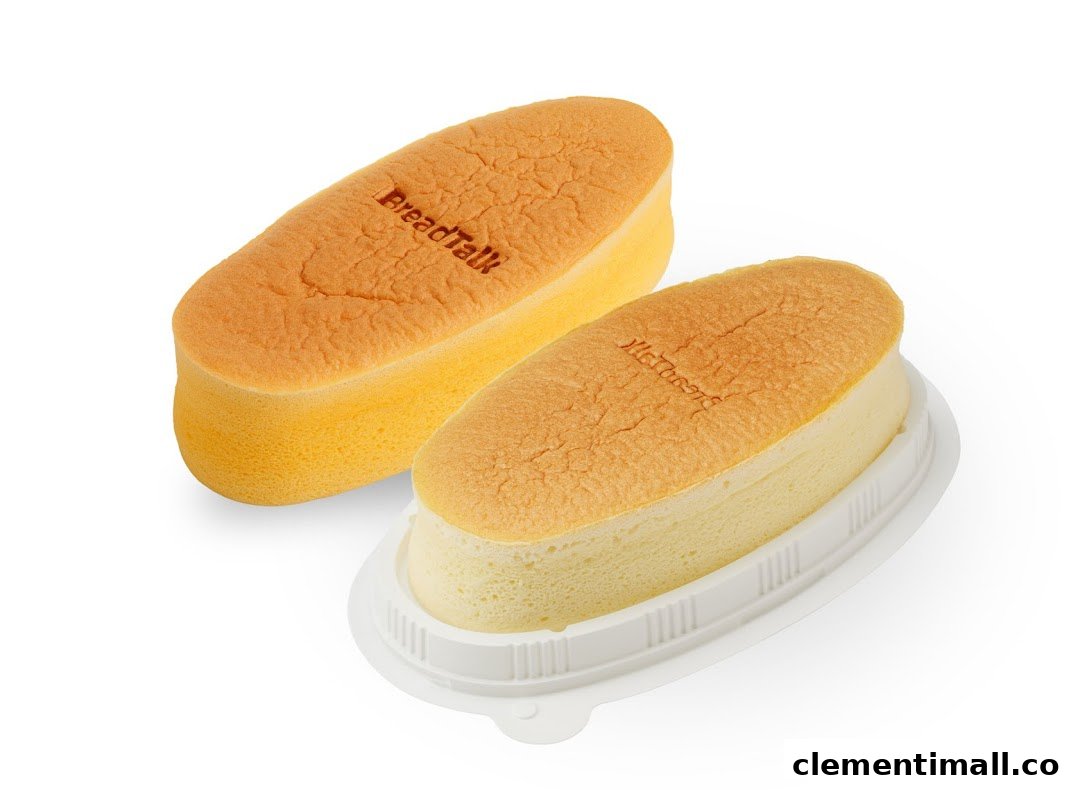 Two golden-brown, oblong sponge cakes, one in a plastic container, on a white background.