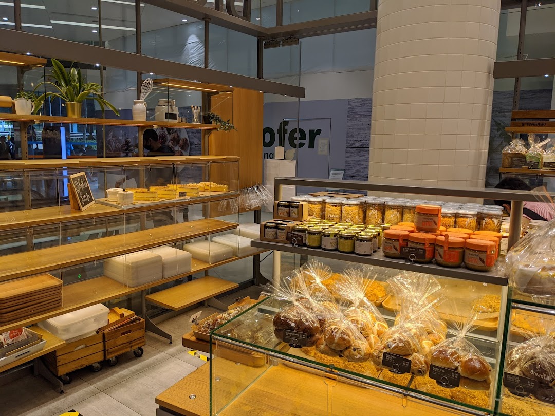 Interior view of BreadTalk bakery showcasing various baked goods, spreads, and display shelves.