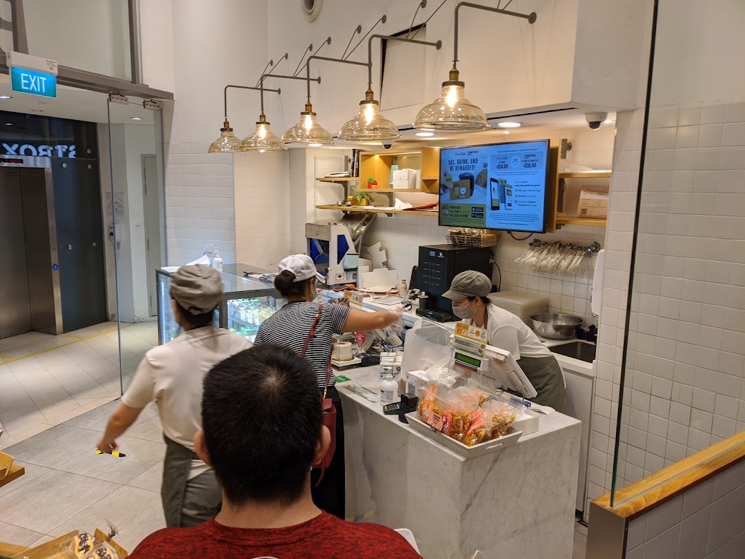 Interior view of BreadTalk with staff serving customers at the counter.