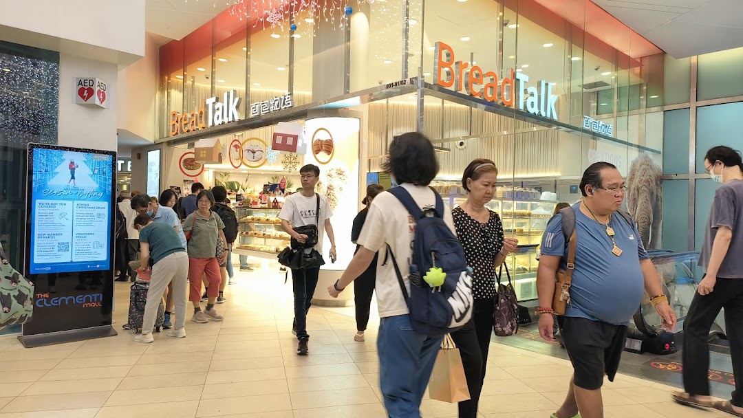 The bustling entrance of BreadTalk bakery, showcasing its inviting display cases and customers.