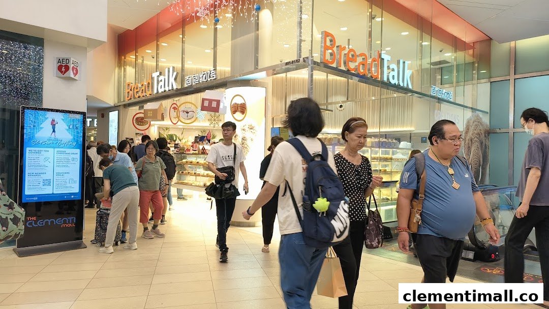 The bustling entrance of BreadTalk bakery, showcasing its inviting display cases and customers.
