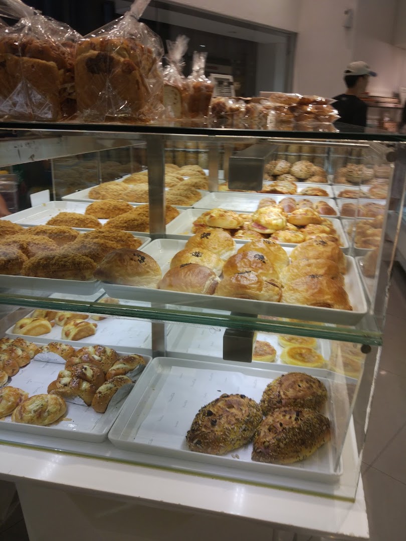 A vibrant display case showcasing a wide variety of freshly baked breads and pastries at BreadTalk.