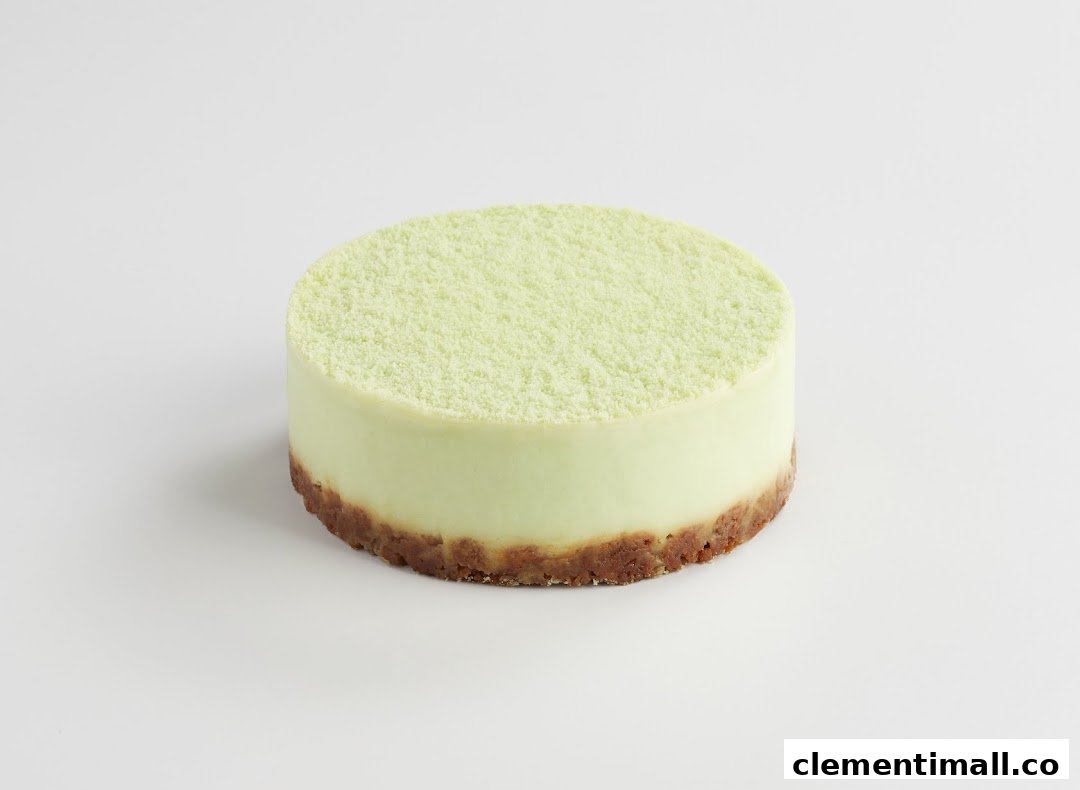 A light green cake with a crumbly top and a brown crust base on a white background.