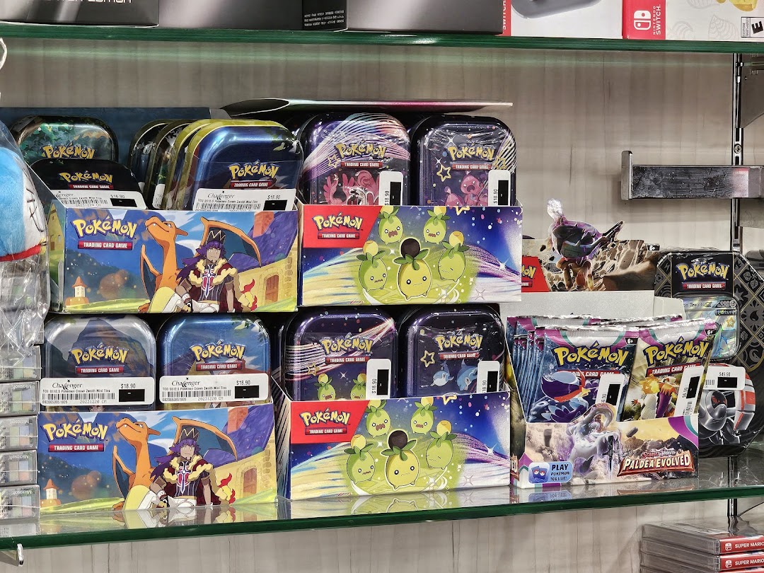 A display shelf filled with various Pokémon Trading Card Game products, including tins and booster packs.