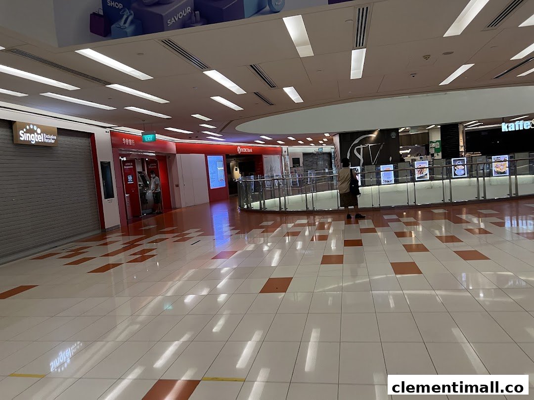 A wide interior view of Clementi Mall, featuring various shops and a person.