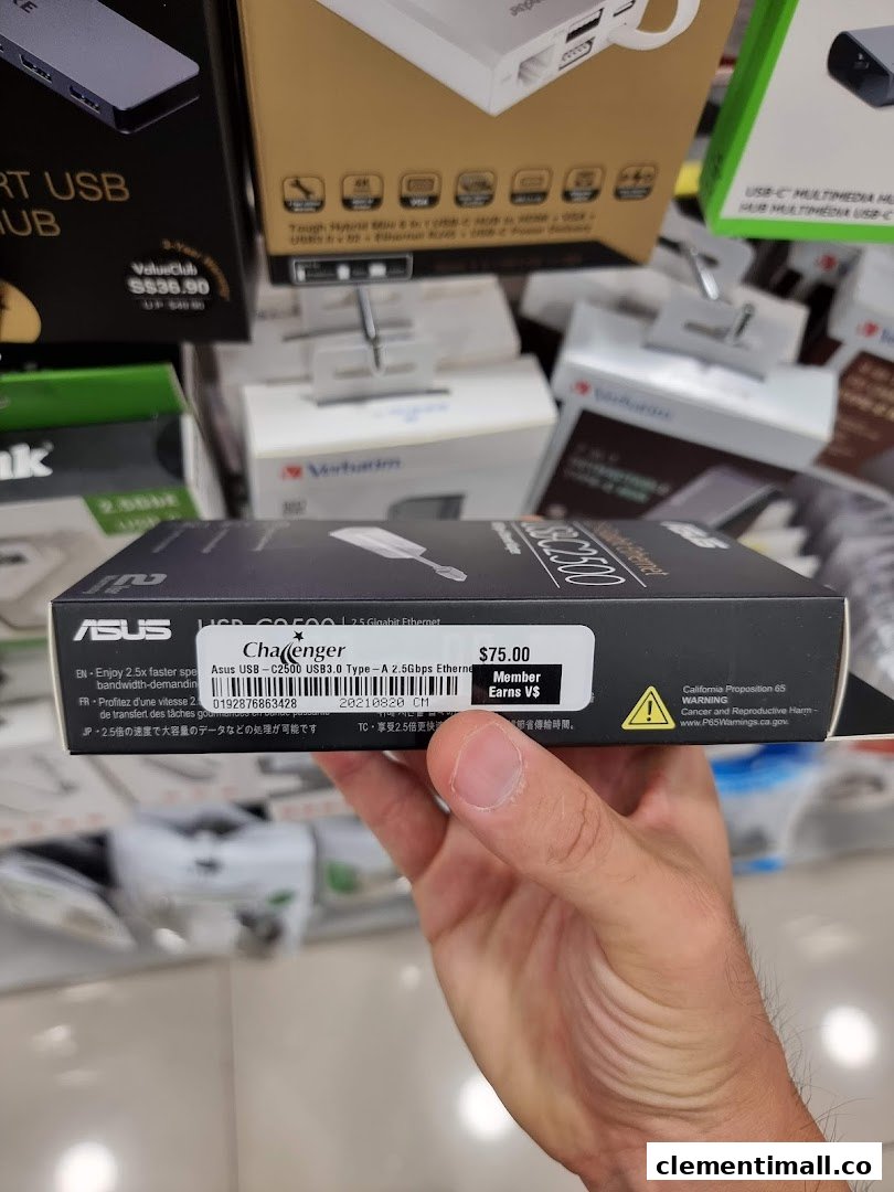 A hand holds an ASUS networking product box with a Challenger price tag in a retail store.