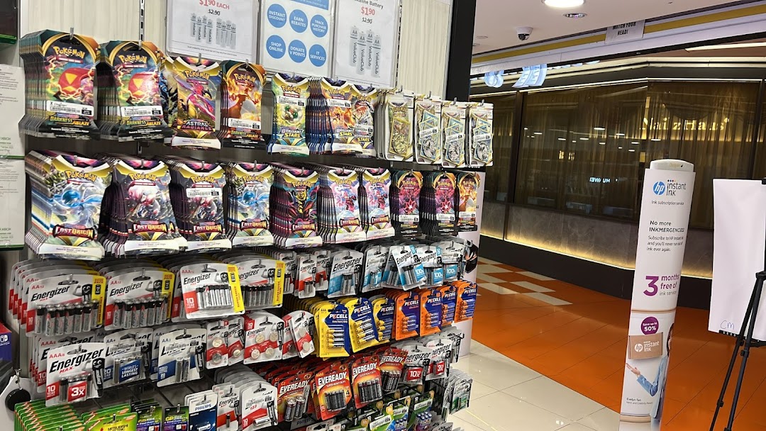 Shelves inside Challenger Clementi Mall displaying Pokémon trading card packs and various brands of batteries.