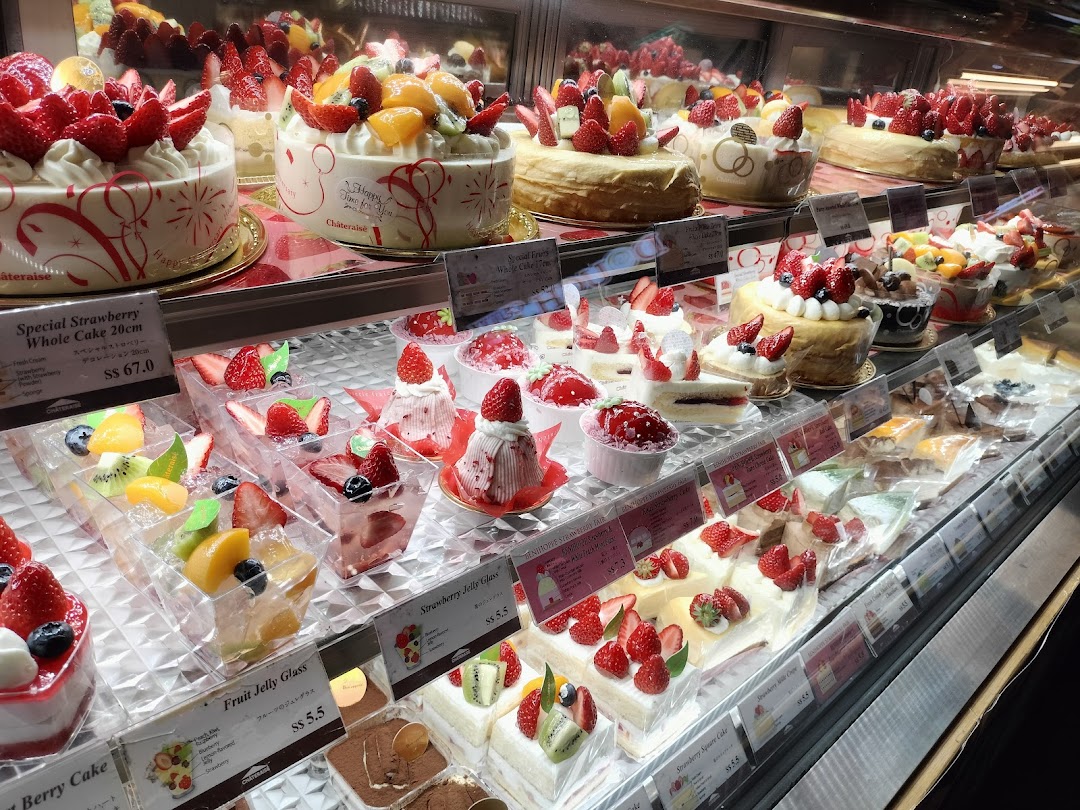 A vibrant display of fresh fruit cakes and desserts in a refrigerated display case at Châteraisé.