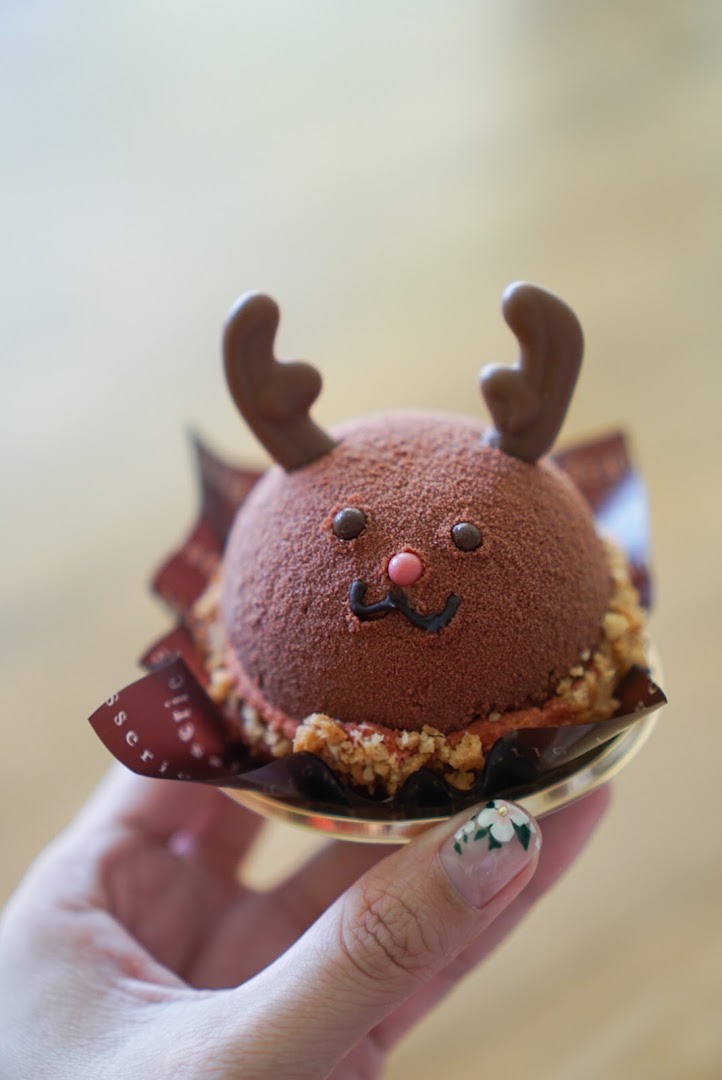 A hand holds a delightful chocolate reindeer dessert from Châteraisé.
