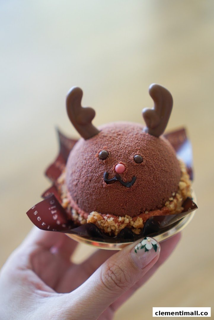 A hand holds a delightful chocolate reindeer dessert from Châteraisé.