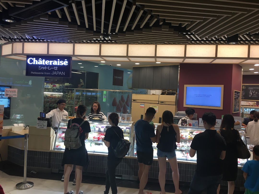 Customers queuing at Châteraisé, a Japanese patisserie, with display cases of cakes and desserts.