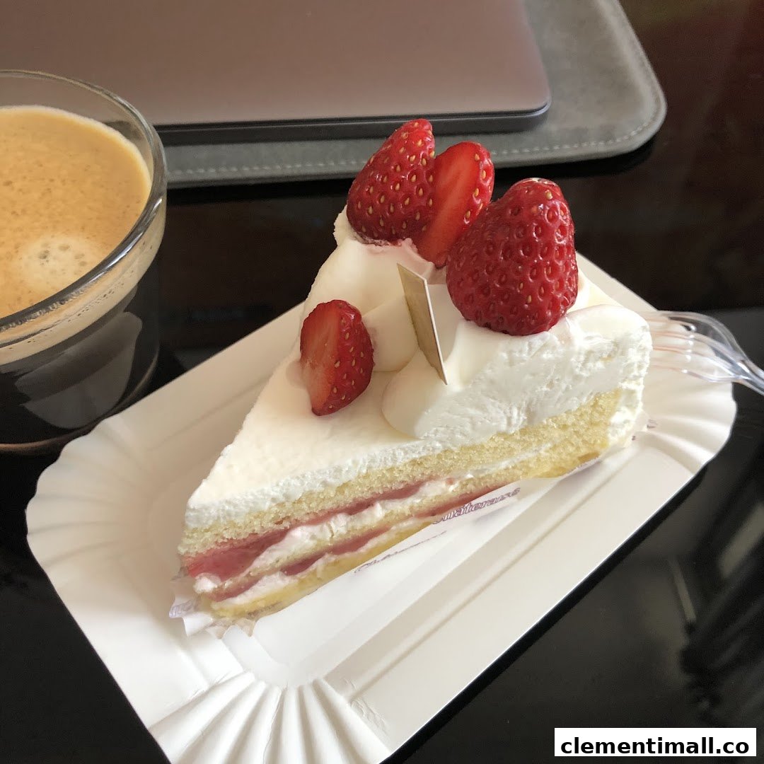 A delicious slice of strawberry shortcake with fresh strawberries and cream, served with a cup of coffee.