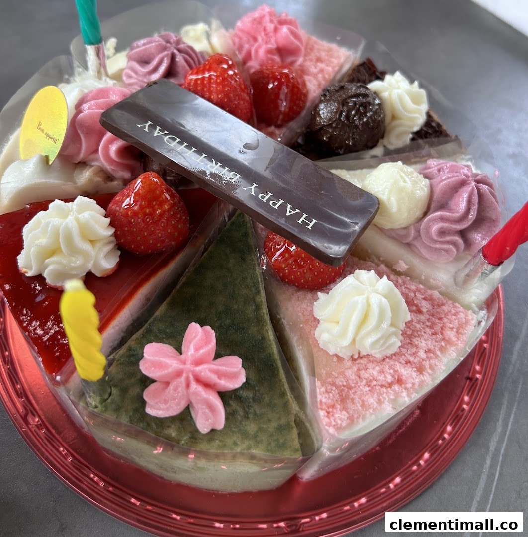 A vibrant assortment of cake slices forming a whole cake, adorned with fruits, cream, and a 'Happy Birthday' chocolate.