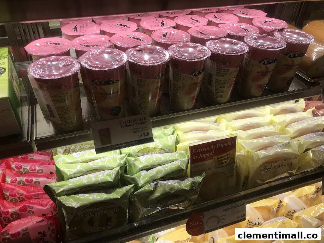 A refrigerated display case showcasing a variety of Japanese desserts and beverages, including smoothies and cream rolls.