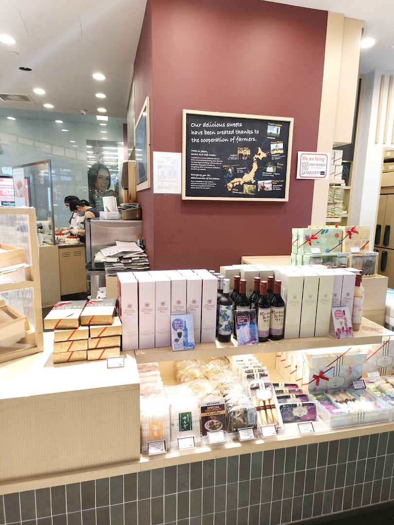 Interior view of Châteraisé, showcasing a display of Japanese sweets, beverages, and staff preparing items.