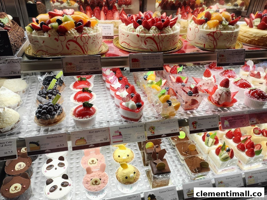 A vibrant display case showcasing a wide variety of fresh fruit cakes, tarts, and delightful desserts.