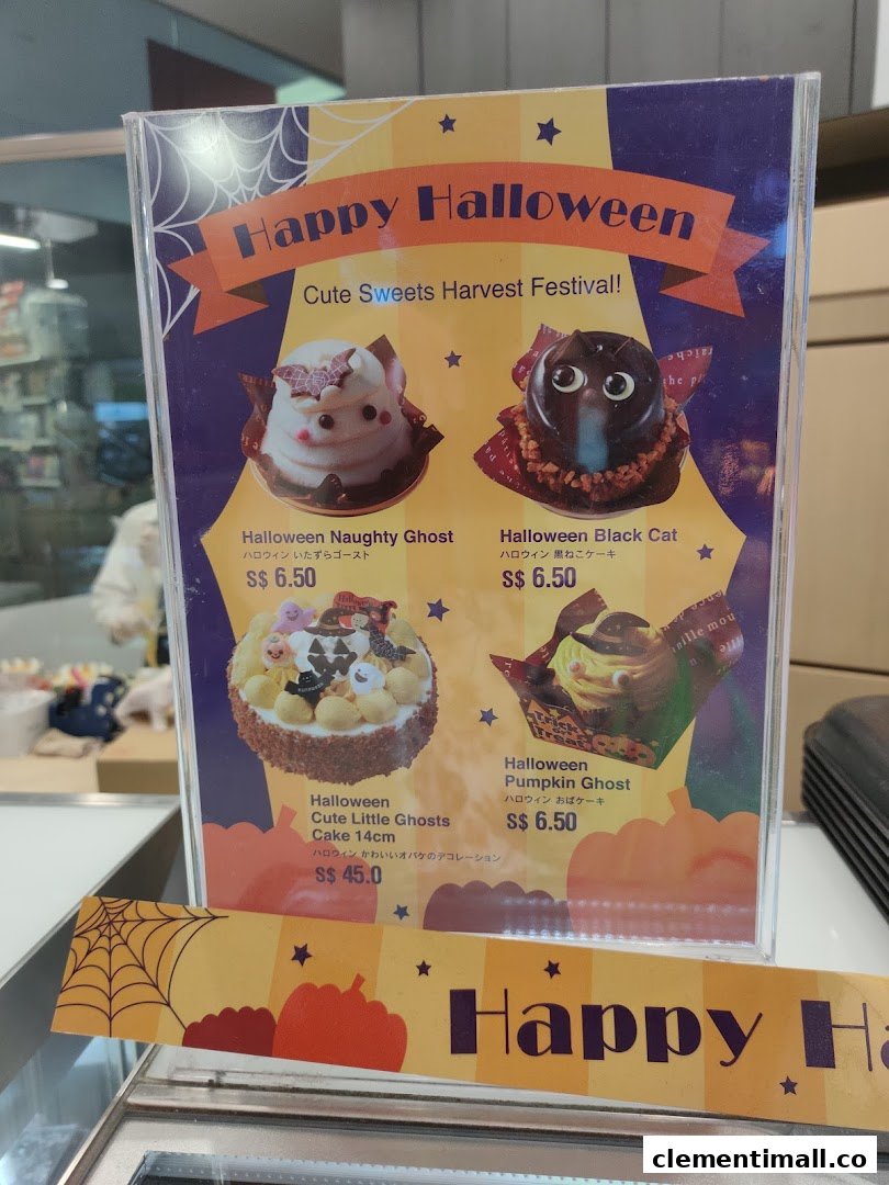 A display stand showcasing Châteraisé's Halloween-themed cakes and desserts with prices.