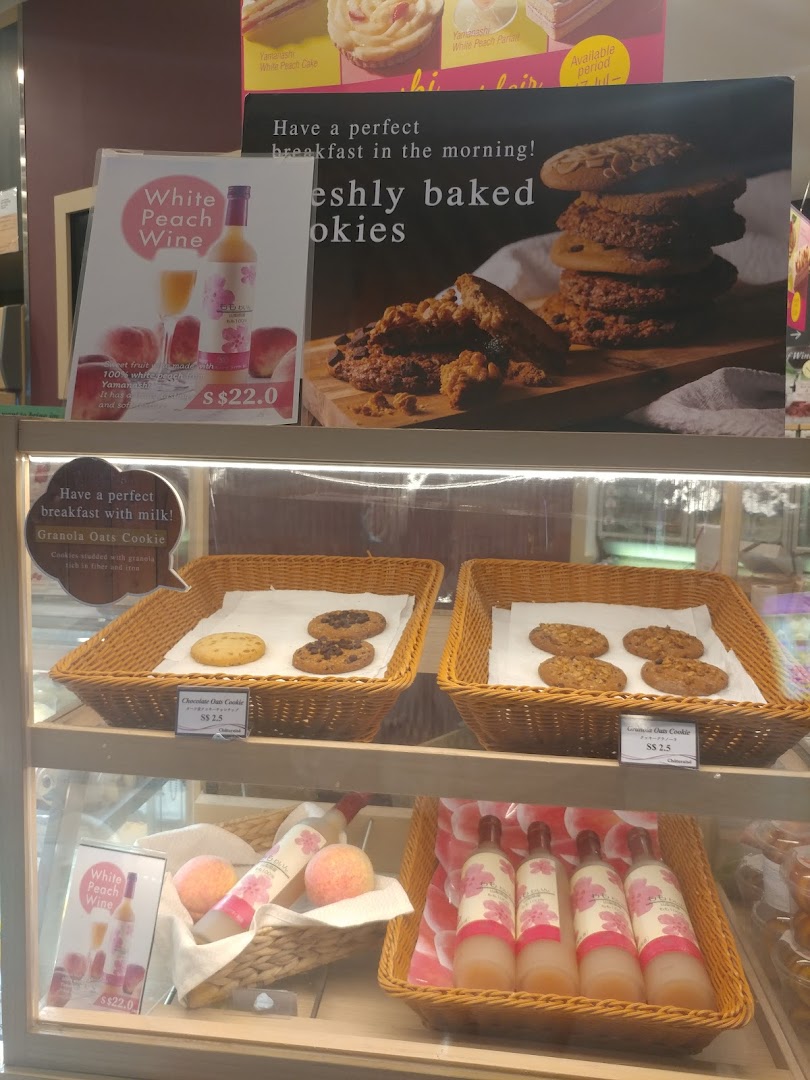 A display case at Châteraisé featuring freshly baked cookies, peach wine, and promotional signs.