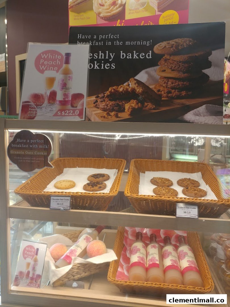 A display case at Châteraisé featuring freshly baked cookies, peach wine, and promotional signs.