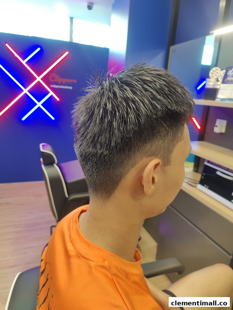 A customer showcases a fresh haircut inside Clippers Barber, featuring modern neon decor.