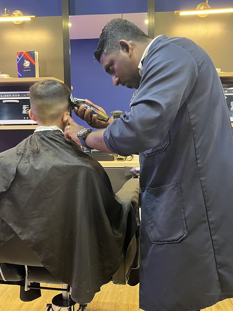 A skilled barber meticulously trims a client's hair inside Clippers Barber at Clementi Mall.
