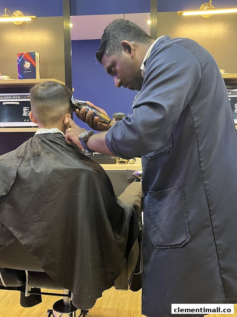 A skilled barber meticulously trims a client's hair inside Clippers Barber at Clementi Mall.
