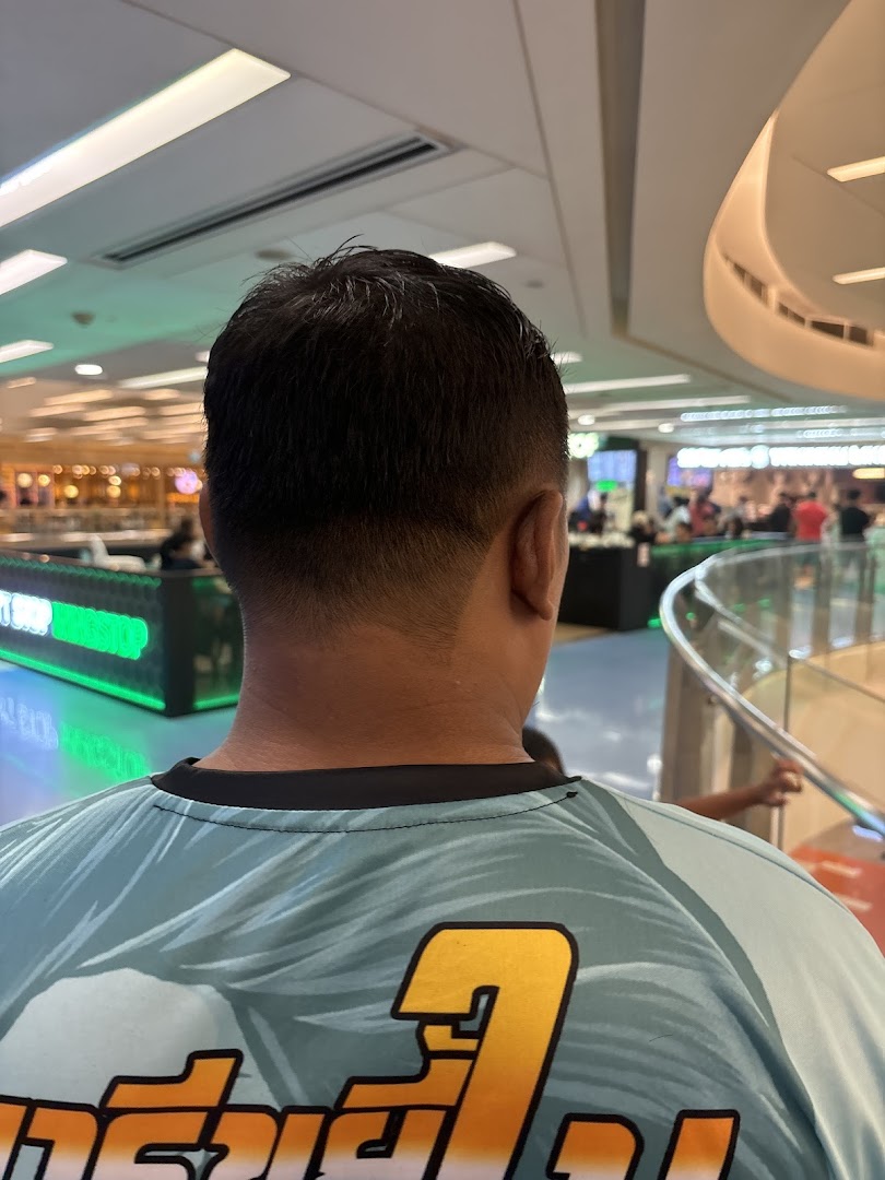Rear view of a person with a fresh haircut, showing a clean fade and the mall interior.