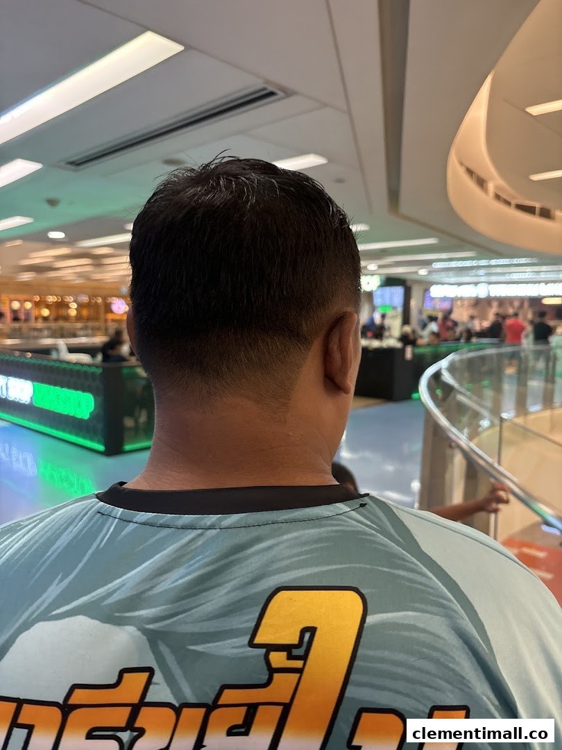 Rear view of a person with a fresh haircut, showing a clean fade and the mall interior.