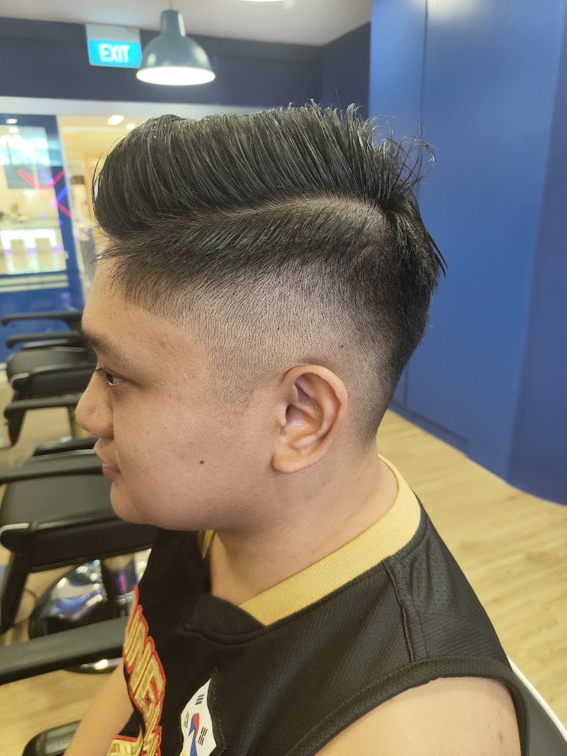 A customer showcasing a fresh, stylish haircut with a fade and pompadour at Clippers Barber.