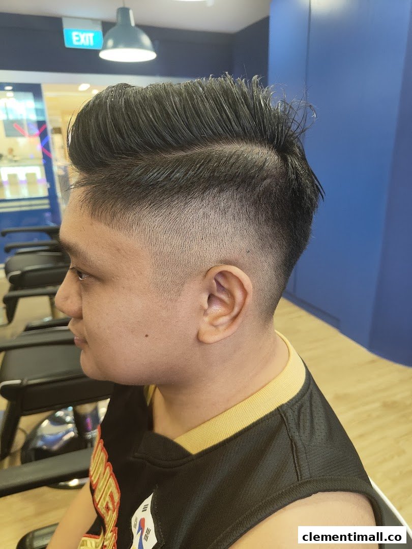 A customer showcasing a fresh, stylish haircut with a fade and pompadour at Clippers Barber.