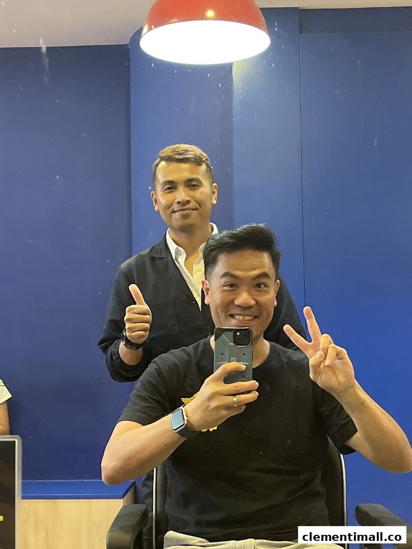 A happy customer takes a selfie with a barber, showing satisfaction with their haircut experience.