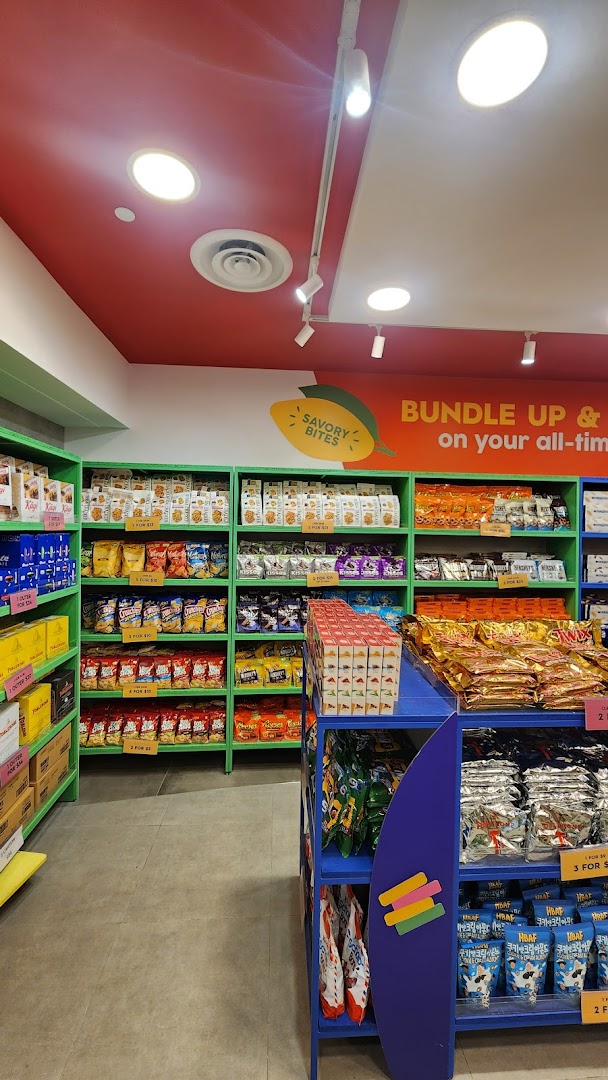 Interior view of Cocoa Pods by The Cocoa Trees, showcasing shelves filled with a variety of snacks and confectionery.
